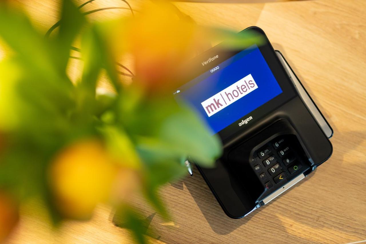 Mk Hotel Tirana Rinas ภายนอก รูปภาพ A mobile phone with the MK1Hotels logo on the screen